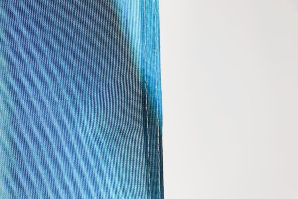 Close-up of vibrant blue feather flag fabric for outdoor advertising.