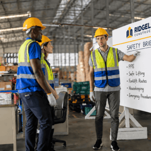 Construction workers in safety gear during safety briefing at Big Value Banners.