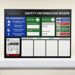 Safety information board with first aid, emergency, and fire action details for dry wipe boards.